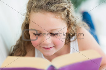 Girl reading a book on the sofa