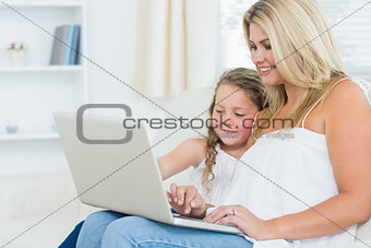 Smiling mother and daughter on the laptop