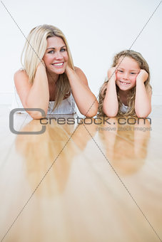 Laughing mother and daughter resting on the floor