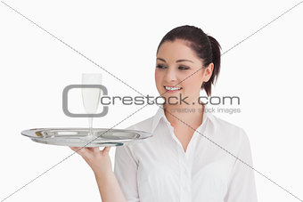 Woman looking on tray with glass