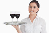 Woman holding tray with glasses of red wine