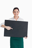 Waitress pointing to black board she is holding