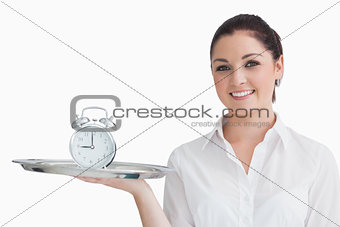 Waitress holding alarm clock on a tray