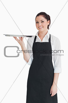 Smiling woman holding an empty silver tray