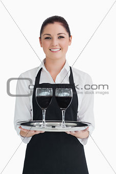 Cheerful waitress holding two glassed of wine