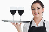 Cheerful waitress holding two glasses of wine