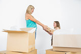 Happy mother and daughter holding moving boxes