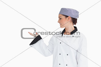Chef holding hand out to left