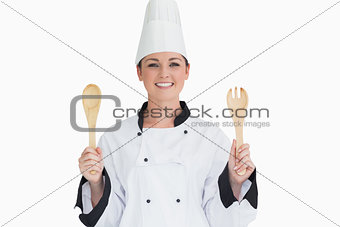Cook holding wooden salad tosses