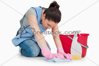 Serious cleaning woman wiping up the floor