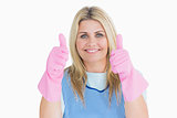 Cheerful cleaner putting thumbs up with pink gloves