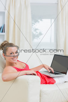 Woman typing on laptop and smiling