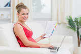 Woman holding notepad and laptop