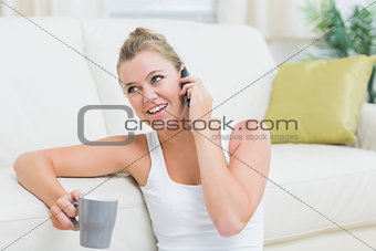 Woman phoning while drinking coffee