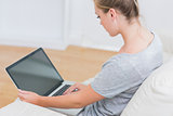 Blonde typing on laptop in living room