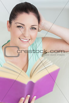 Woman holding a book while sitting on the couch