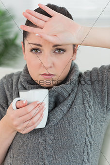 Woman sitting on the couch and feeling ill