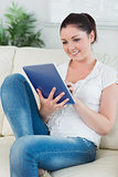 Woman using a tablet pc while sitting on the couch