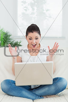 Lucky woman using a laptop on the couch