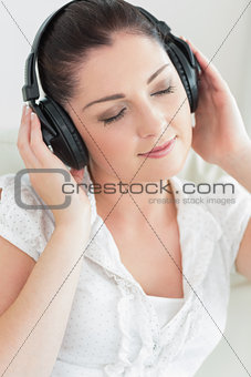 Woman listening to music and sitting on the couch
