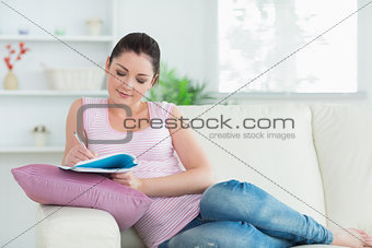 Relaxing woman on a couch taking notes