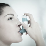 Woman with asthma using the inhaler