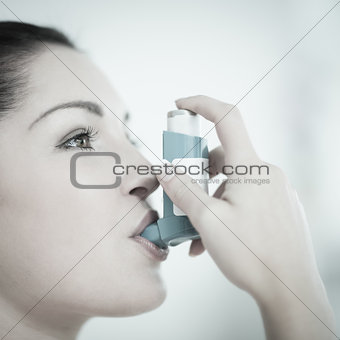 Woman with asthma using the inhaler