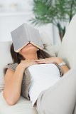 Brunette sleeping with her book on the head