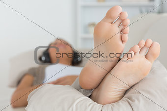 Woman with her feet up listening to music