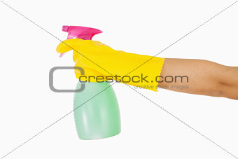 Woman in yellow rubber gloves holding window cleaner