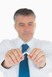 Man concentrating on breaking cigarette