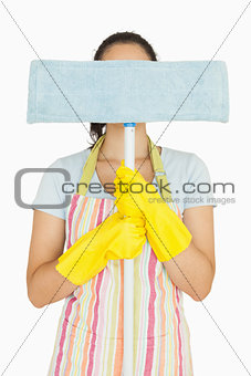 Young woman hiding behind mop