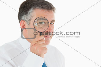 Businessman looking through magnifying glass