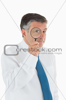 Inquisitive businessman with magnifying glass