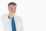 Smiling businessman using magnifying glass