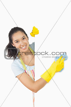 Smiling woman cleaning white surface