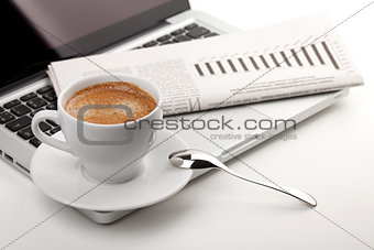 Cappuccino cup with laptop and newspaper