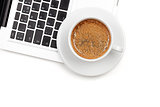 Cappuccino cup on laptop. Above view