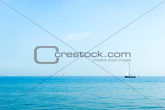 Seascape with sailboat the background of the blue sky.