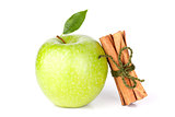 A Ripe Green Apple with water drops and cinnamon sticks