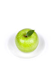 A Ripe Green Apple with leaf on plate