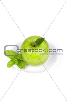 A Ripe Green Apple with mint on plate
