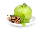 A Ripe Green Apple with mint and cinnamon on plate
