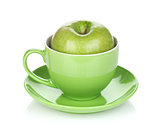 Ripe green apple in tea cup