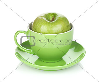 Ripe green apple in tea cup