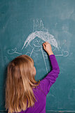 Young girl drawing on chalkboard