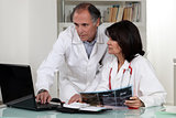 Doctors looking at laptop screen