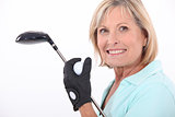 mature blonde woman taking golf club and golf ball