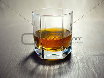 Glass beaker of cold whisky with ice