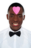 African man with pink paper heart on his forehead